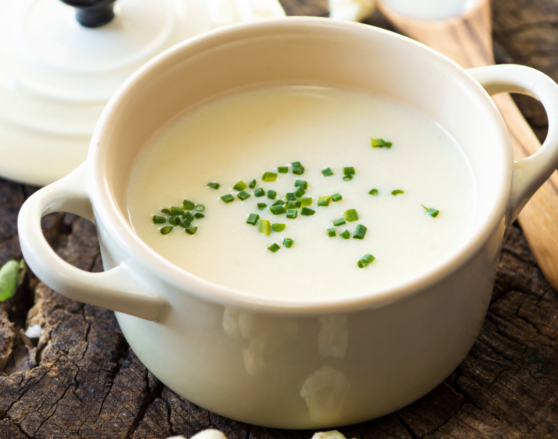 crock of creamy cauliflower soup garnished with chives