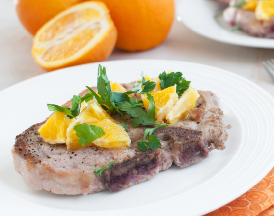 pork chop topped with mandarin oranges and herbs
