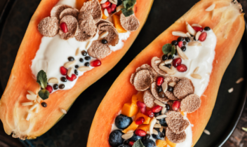 papaya cut in half lengthwise filled with yogurt and topped with fruit and granola