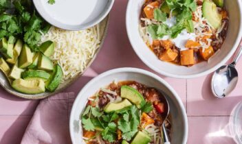 bowls of black bean sweet potato chili topped with avocado and cilantro