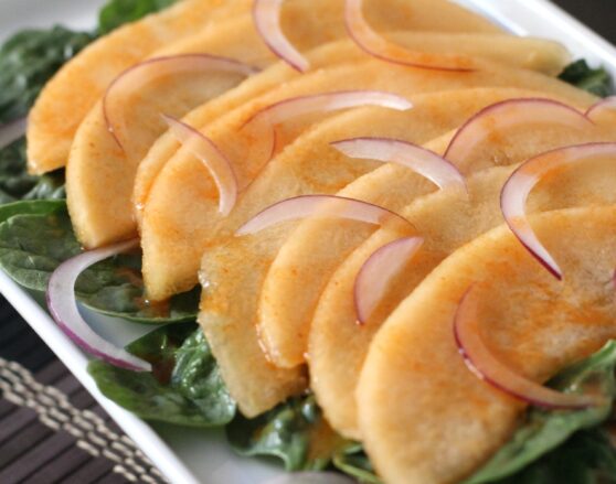 slices of cantaloupe with lime dressing and red onions
