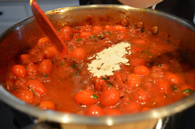 Stir in canned tomatoes with juice, red pepper flake, garlic and powders.