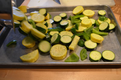 On separate unlined sheet tray spread out squash and pepper mixture.