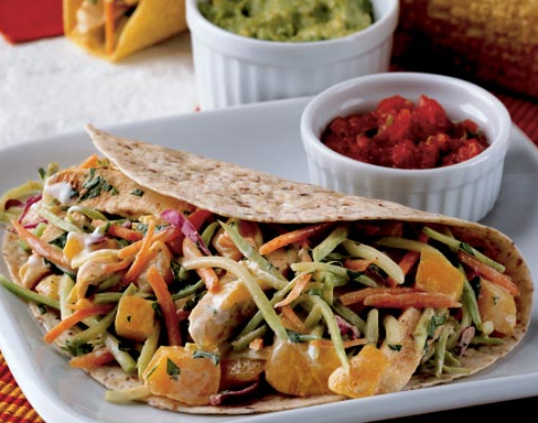 chicken tacos topped with broccoli slaw and peaches in a creamy dressing