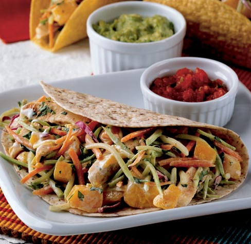 chicken tacos topped with broccoli slaw and peaches in a creamy dressing