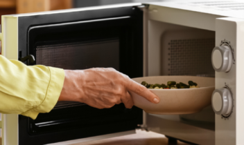 woman placing vegetables in microwave