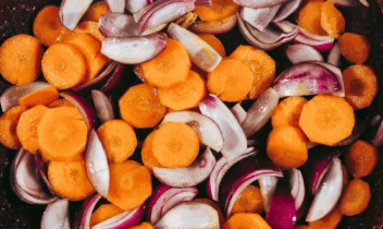 cooked carrots and red onion in a pan