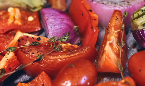 red pepper, tomatoes, red onion, thyme on a sheet pan