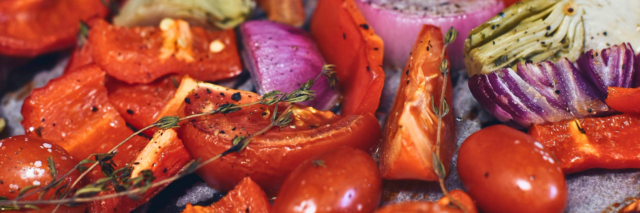 red pepper, tomatoes, red onion, thyme on a sheet pan