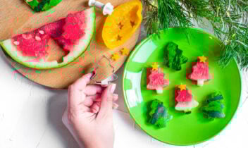 person holding a christmas tree cookie cutter and watermelon