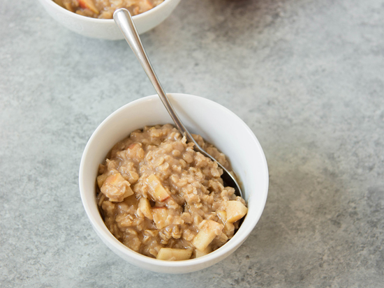 bowl of hot oatmeal with diced apples in it
