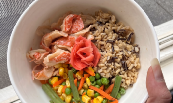brown rice with imitation crab meat, frozen veggies, and pickled ginger in a bowl