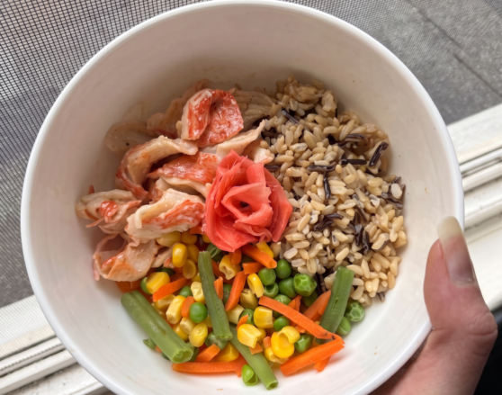 quick sushi bowl-edited brown rice with imitation crab meat, frozen veggies, and pickled ginger in a bowl